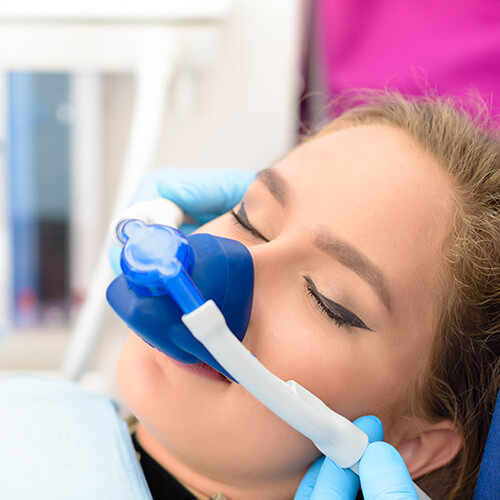 A young patient wearing a nasal hood and using nitrous oxide